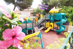 A playground with slides and climbing structures, surrounded by greenery. - Zafiro Cala Mesquida (Capdepera)