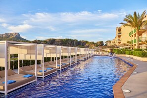 A swimming pool with lounge chairs and a view of a mountain. - Zafiro Cala Mesquida (Capdepera)