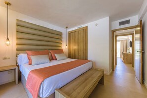 A modern bedroom with a large bed, a wooden headboard, and a bench at the foot of the bed.