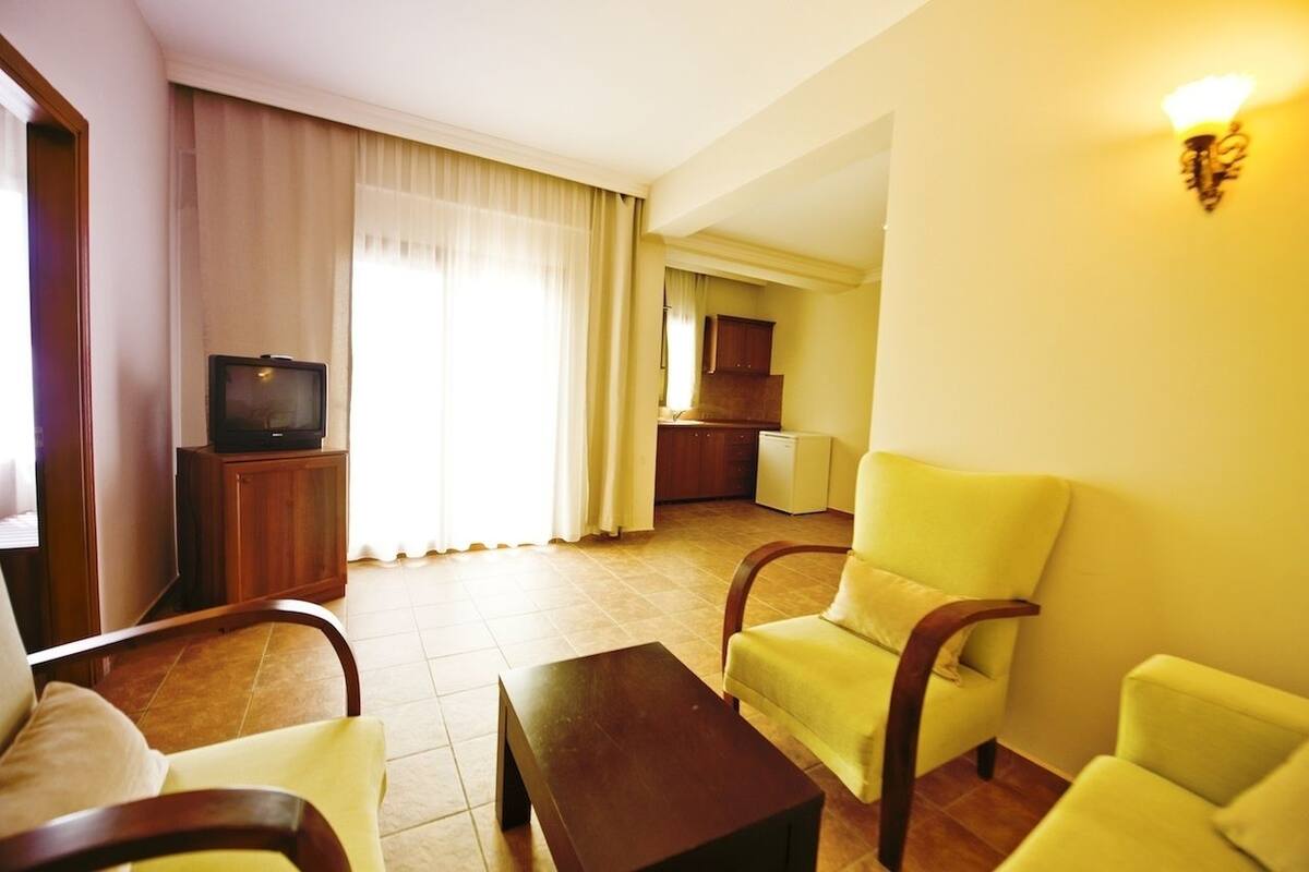 Ett hotellrum med TV, en matplats och ett kök.