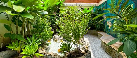 A courtyard with potted plants and a tiled floor.