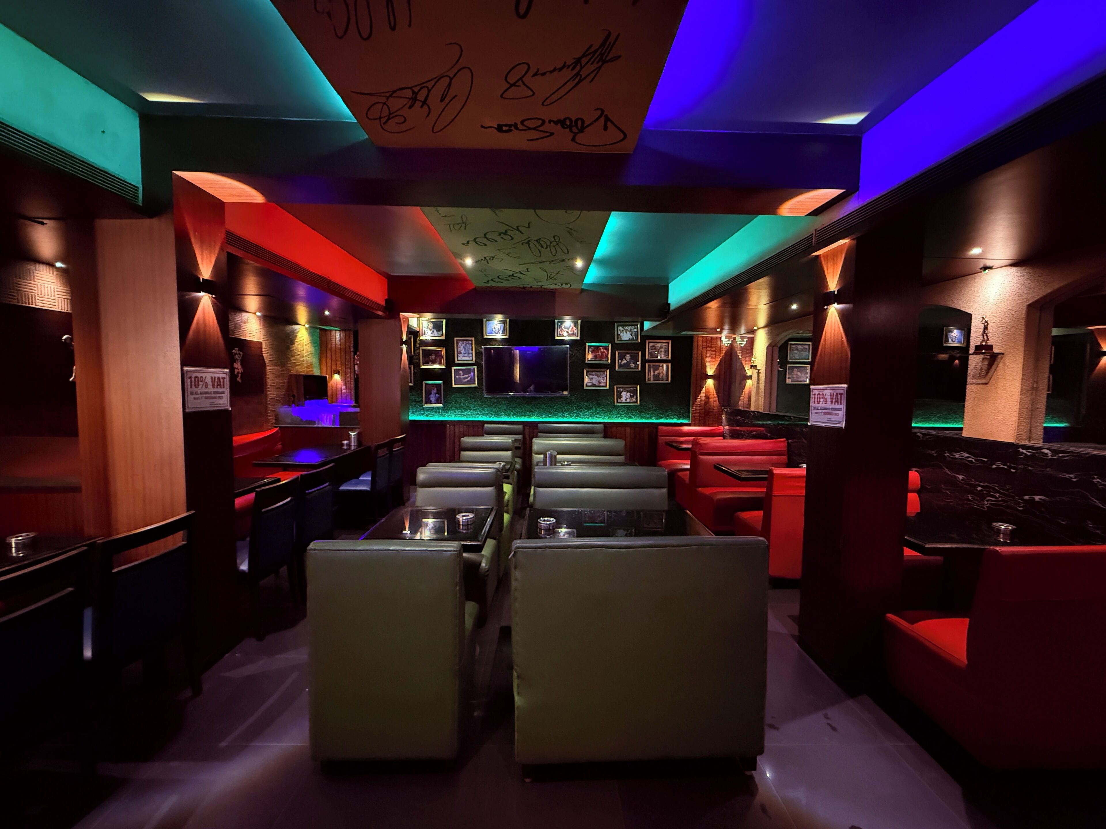 Uma área de bar com iluminação baixa, com cabines e balcão.