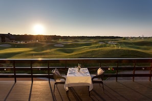 Mesa de comedor para dos con vista a un campo de golf.