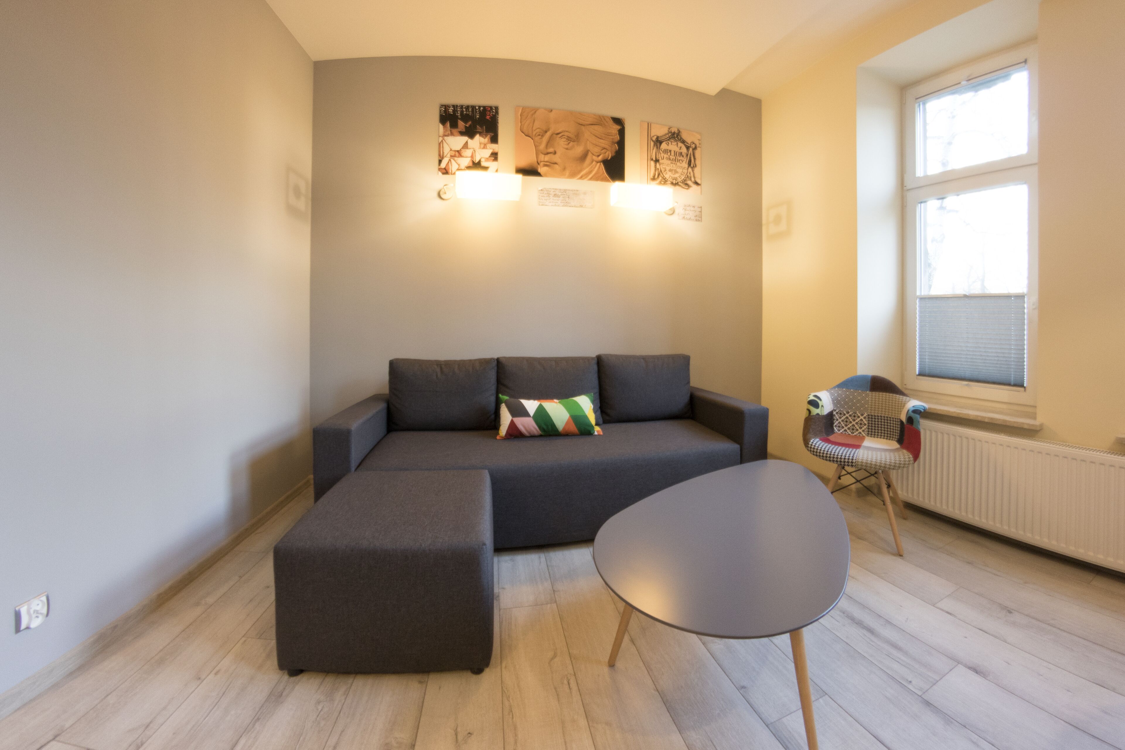 A modern living room with a sectional sofa, a small round table, and a decorative chair.