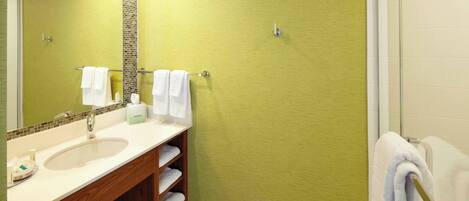 A bathroom with a sink, mirror, and towel rack.