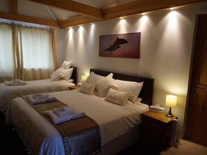 A hotel room with two beds, a painting on the wall, and a lamp on the nightstand. - Orchard House (Royston)
