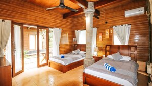 A wooden room with two beds, a ceiling fan, and a sliding glass door leading to an outdoor area. - Villa Happy (Kedonganan)