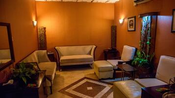 A cozy lounge area with a sofa, armchairs, a coffee table, and a small side table.