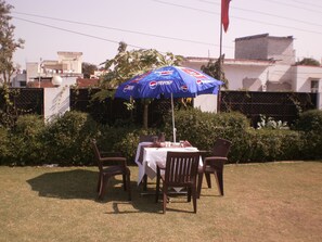 Enjoy a romantic dinner for two under the shade of an umbrella in a serene outdoor setting.