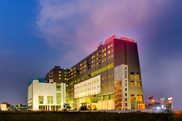 A multi-story hotel with a modern design, featuring a prominent entrance and multiple windows.