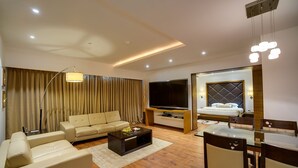 Una sala moderna con sofá, televisión y comedor.