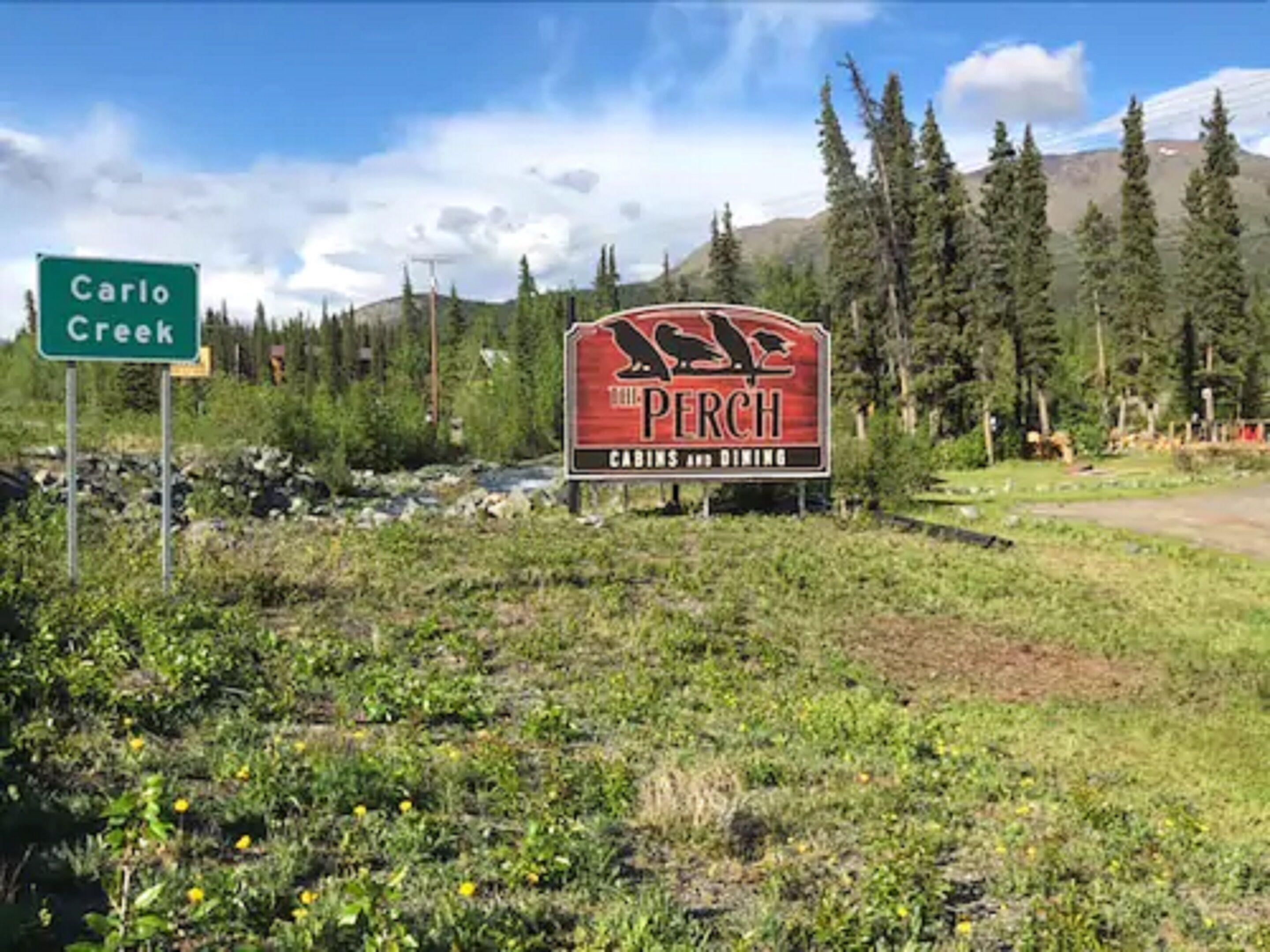 A sign for 'The Perch' with a mountain backdrop.