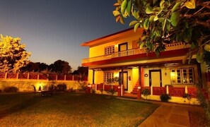 Vista frontal de la propiedad por la tarde o noche