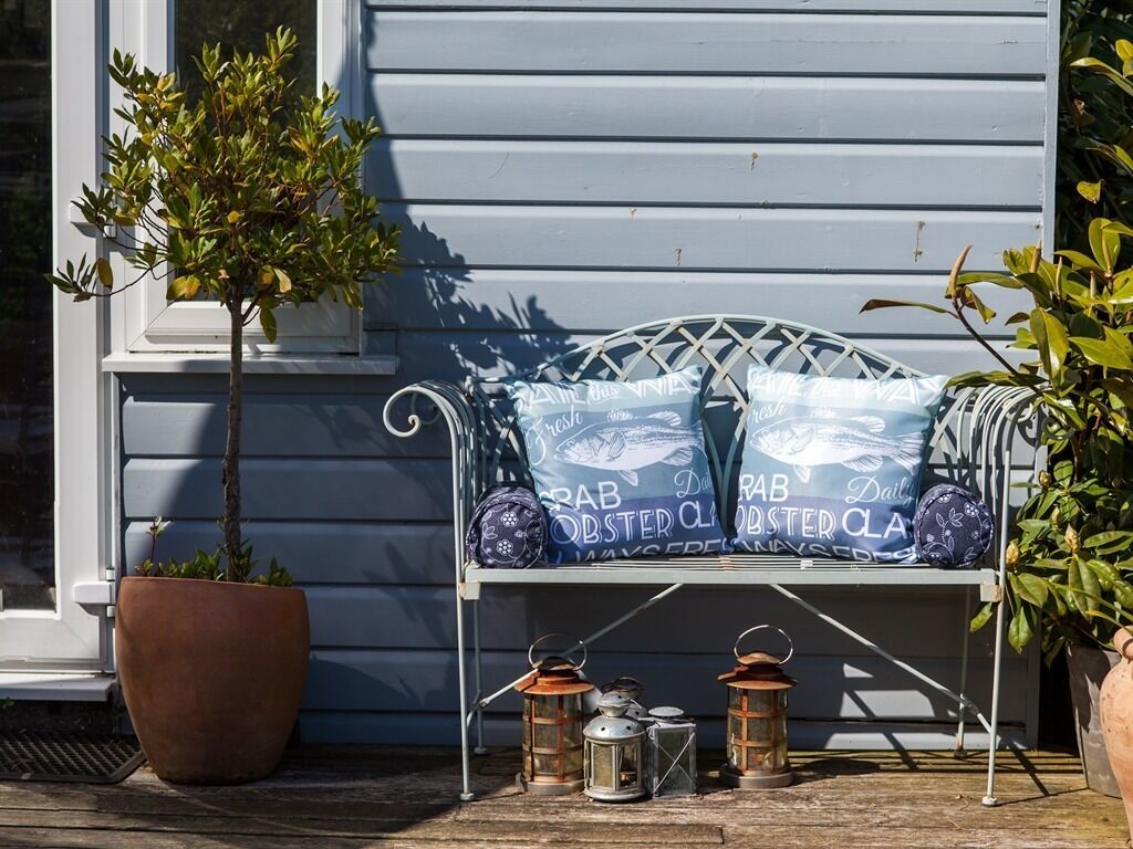 A porch with a bench, potted plants, and bags labeled "Daily Oyster Club."