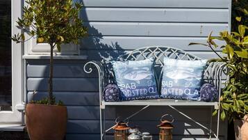 A porch with a bench, potted plants, and bags labeled "Daily Oyster Club."