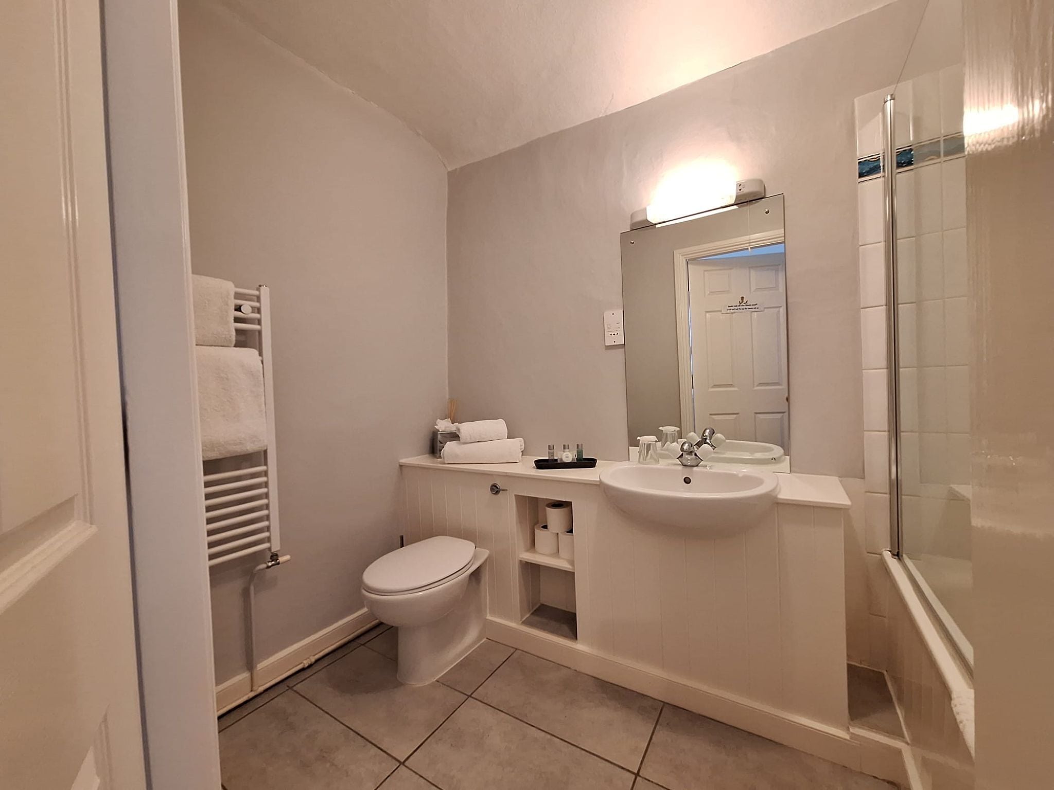 Une salle de bain avec des toilettes, un lavabo et une douche.