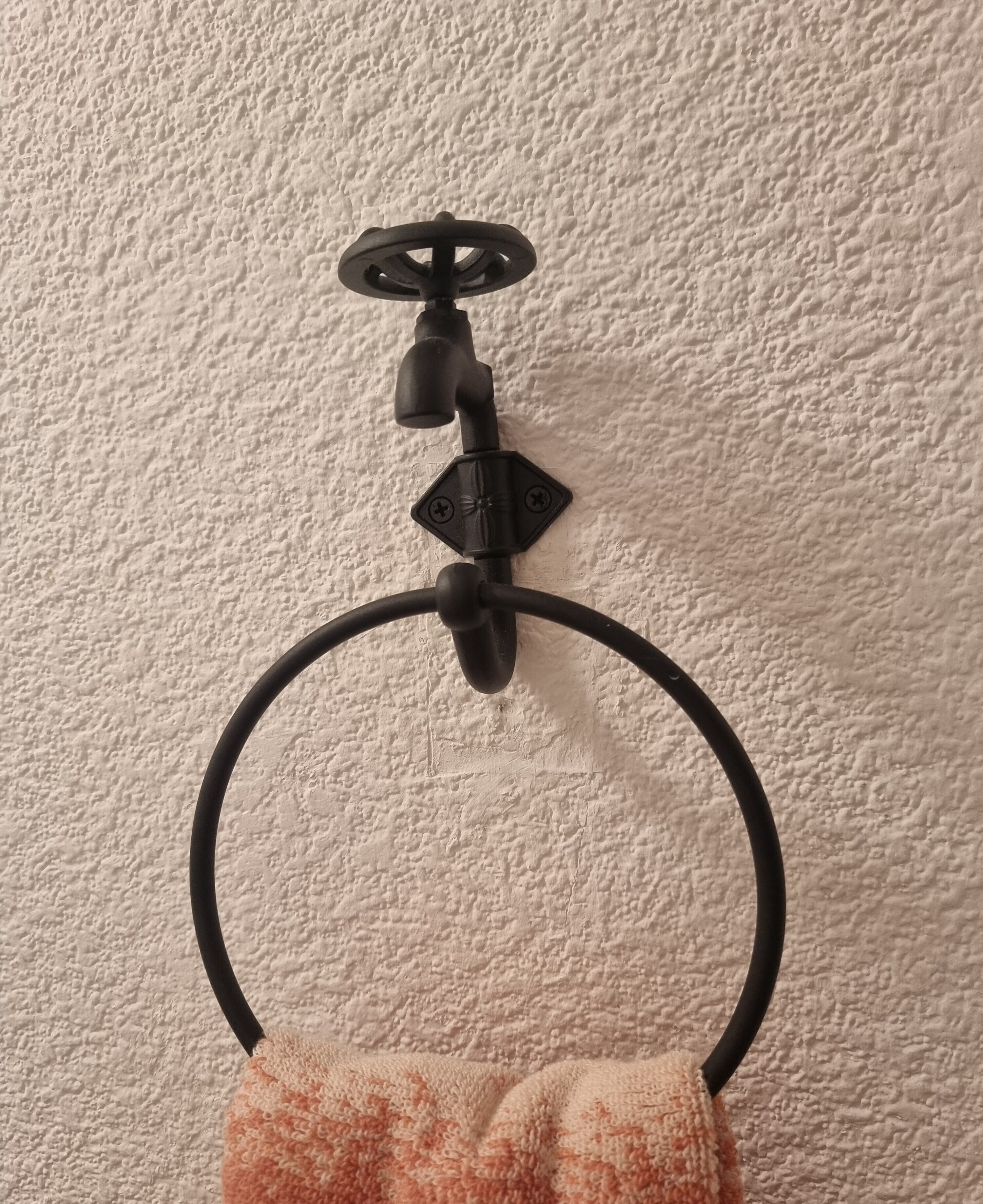 A towel ring mounted on a textured wall.