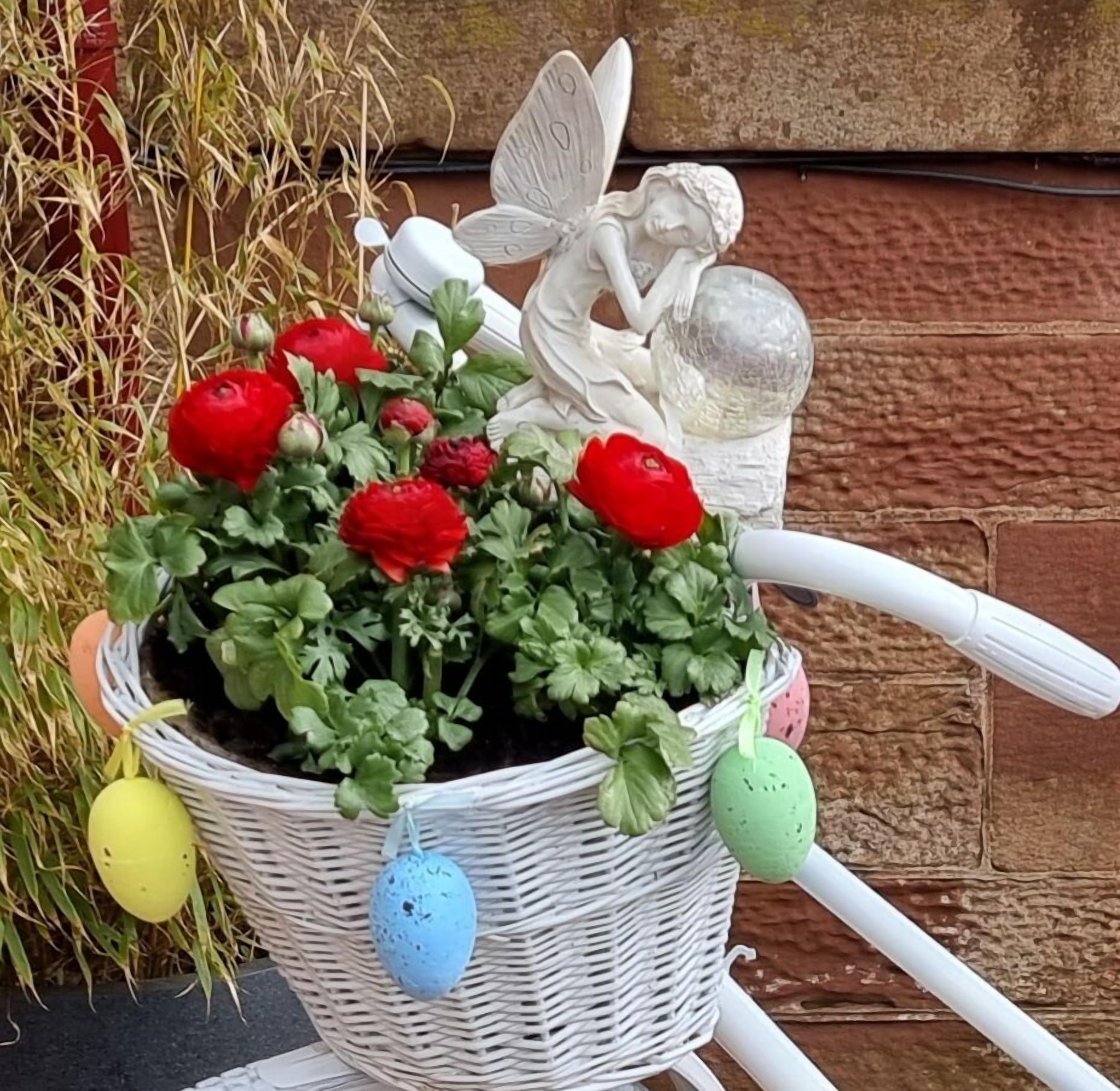 A potted plant with red flowers and a white decorative item.