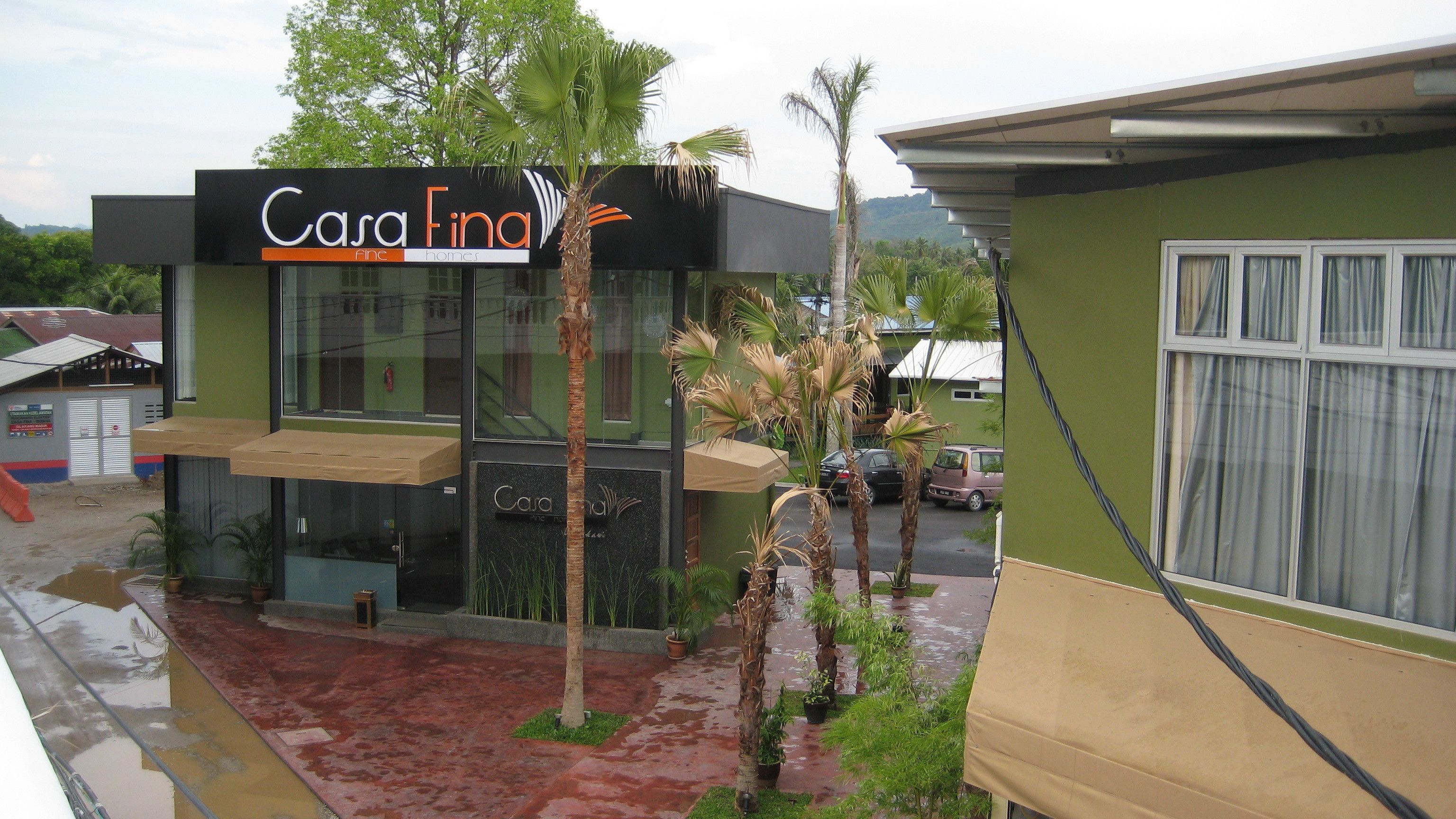 A modern building with a sign reading "Casa Final Fine Homes".
