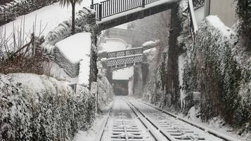 Une voie ferrée recouverte de neige, avec un pont piétonnier enjambant la voie.