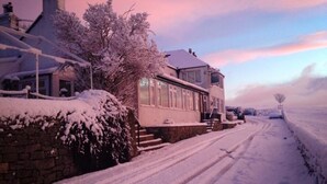 A snow-covered residential street with houses and a clear sky. - Lathkil Hotel (Bakewell)