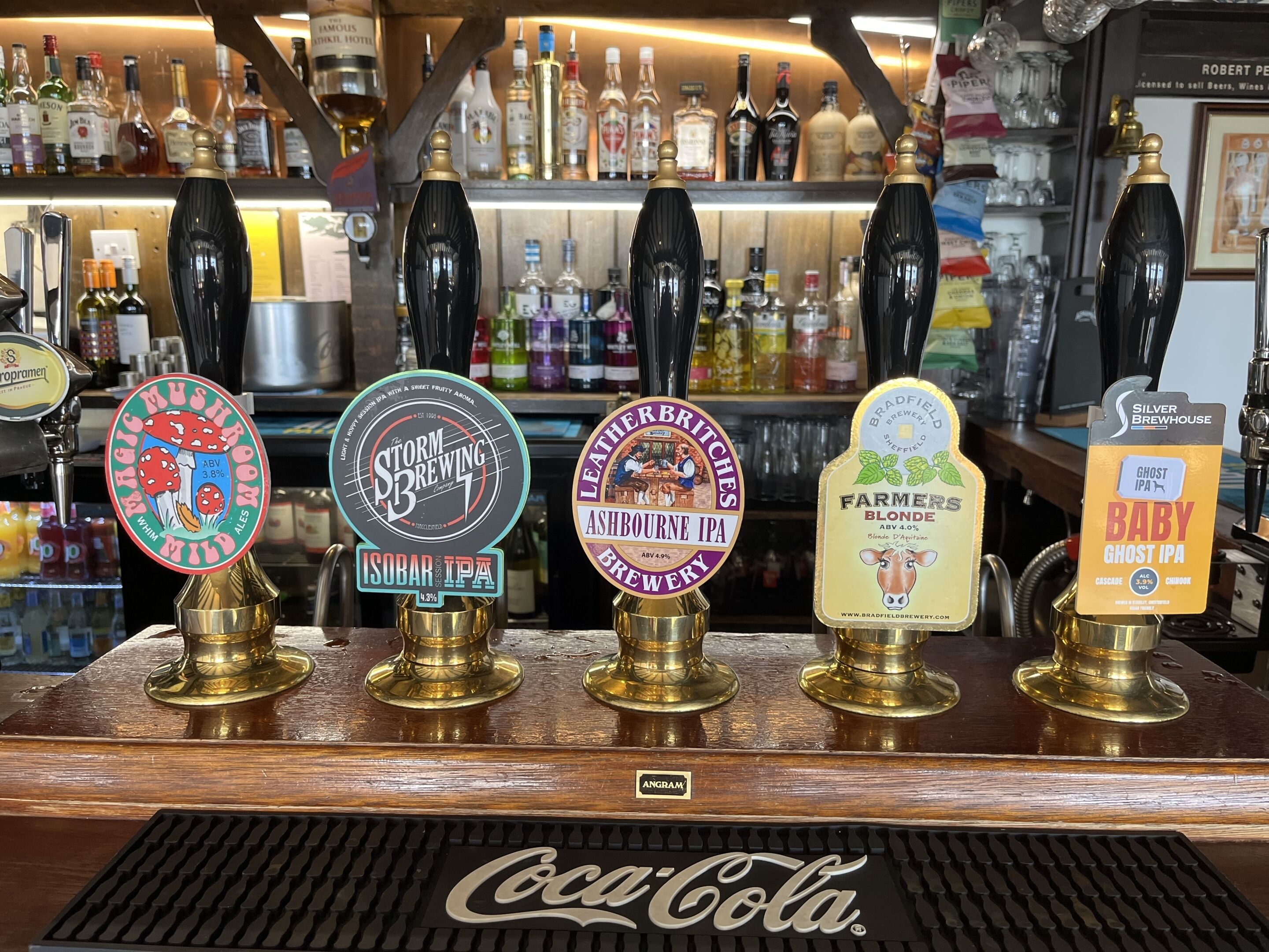 Een bar met verschillende biertaps, waaronder merken zoals Storm Brewing, Isobar IPA, Leather Britches, Farmers Blonde en Ghost IPA.