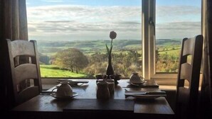 A table set for two with a view of rolling hills and a clear sky. - Lathkil Hotel (Bakewell)