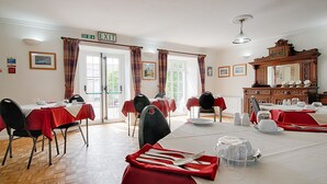A dining area with tables set for meals, chairs, and a buffet table. - Leworthy Farmhouse (Holsworthy)