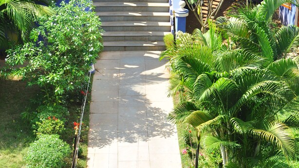 A pathway leading to a pool area with lounge chairs and a staircase.