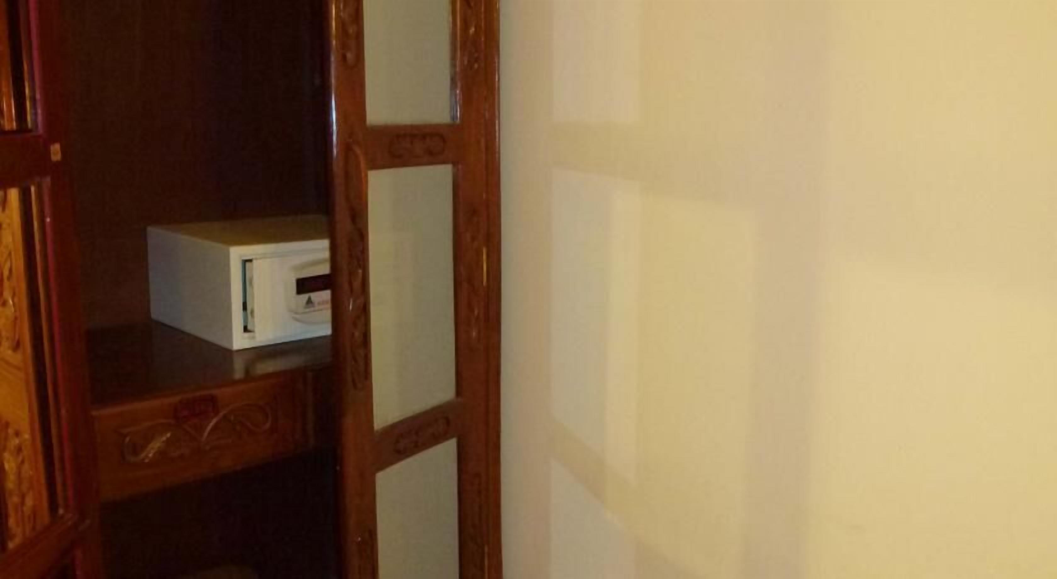 Une porte en bois avec des panneaux de verre et un objet blanc posé sur une étagère.