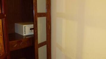 Une porte en bois avec des panneaux de verre et un objet blanc posé sur une étagère.