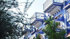 A row of blue buildings with white balconies and detailed architectural features.