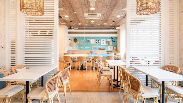 A restaurant with a wooden ceiling, white walls, and wicker chairs. Tables are arranged for dining. - Comfort Inn Naha Tomari Port (Naha)