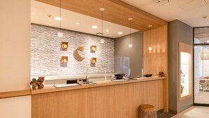 A reception area with a wooden counter, stone wall, and modern pendant lighting. - Comfort Inn Naha Tomari Port (Naha)