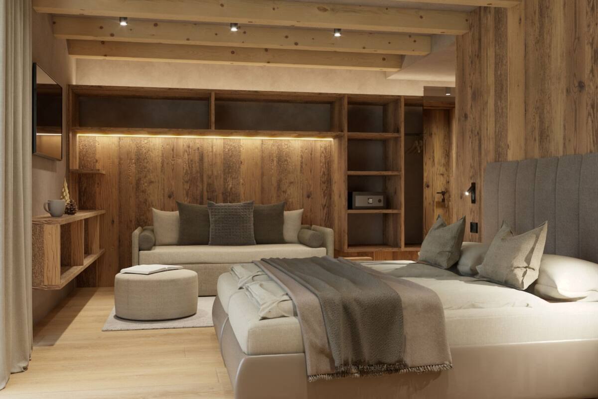 Un dormitorio moderno con una cama grande, un sofá más pequeño y una mesita de noche. Hay un armario de madera y un estante con objetos decorativos.