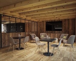 Un ambiente moderno con travi in legno, zona pranzo con tavoli e sedie, cucina con scaffalatura per vini e televisore a schermo piatto montato a parete.