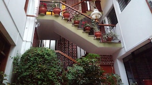 A multi-level outdoor staircase with potted plants, a metal railing, and a hanging light fixture.