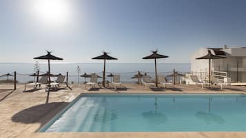 Piscine extérieure, parasols de plage, chaises longues