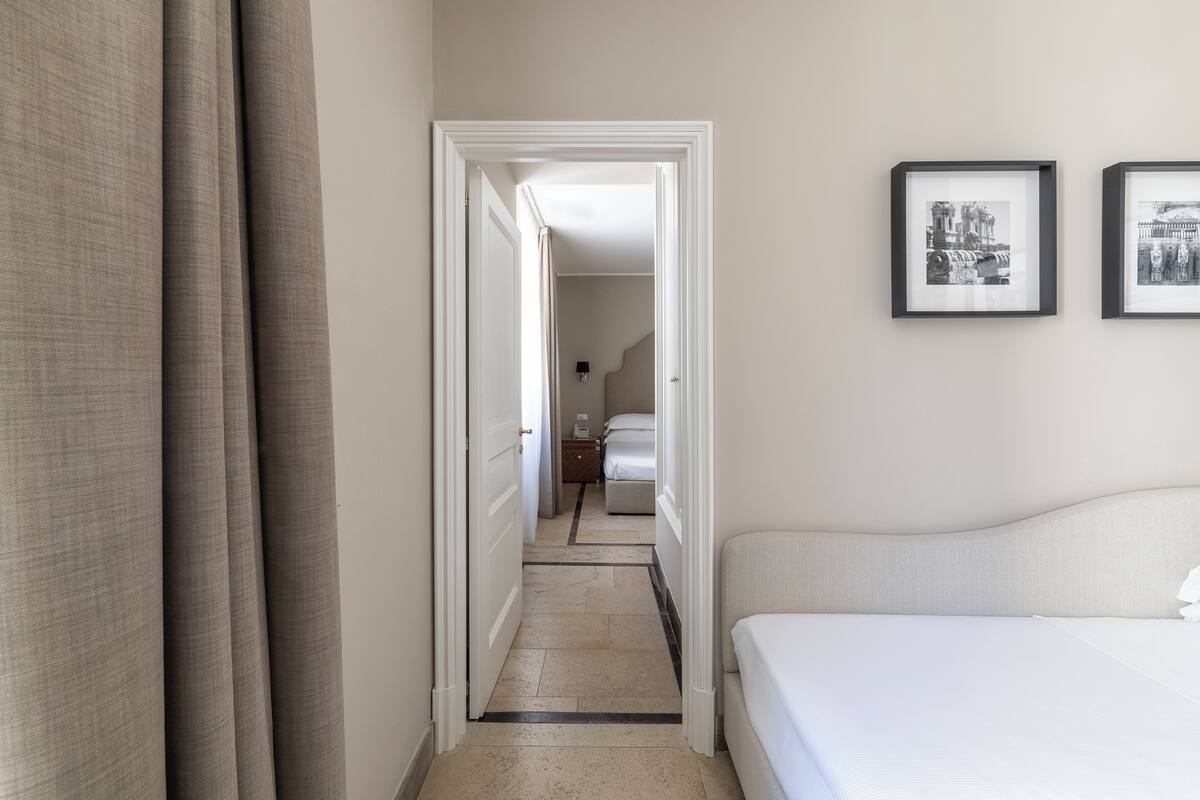 A hotel room with a bed, a nightstand, and a framed picture on the wall.