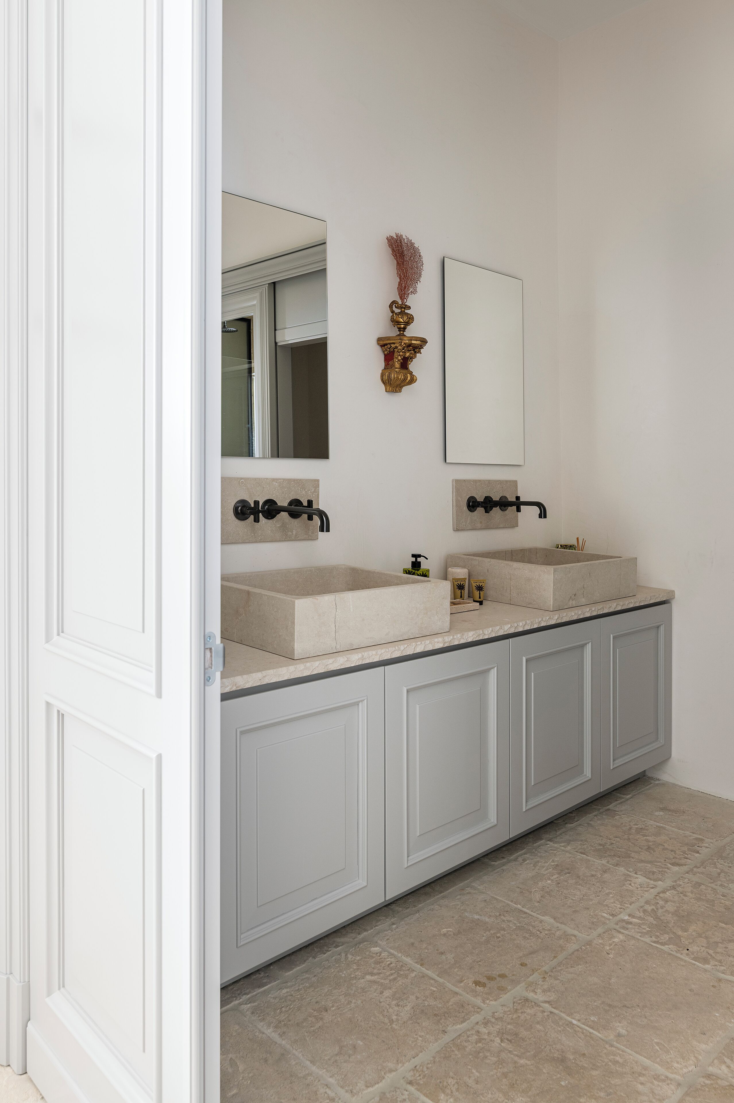 A bathroom with two sinks, a large mirror, and a cabinet.