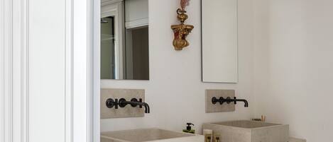 A bathroom with two sinks, a large mirror, and a cabinet.