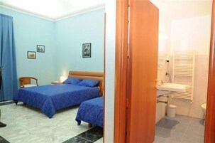 A bedroom with two beds, a wooden chair, and a nightstand.