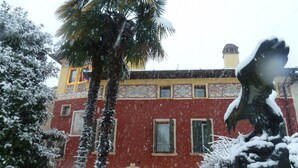 A red building with a large statue in front. - Residence Villa Vinco (Tregnago)