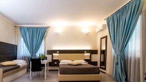 A modern hotel room with a bed, a desk, and a seating area. - Kunesias (Cinisi)