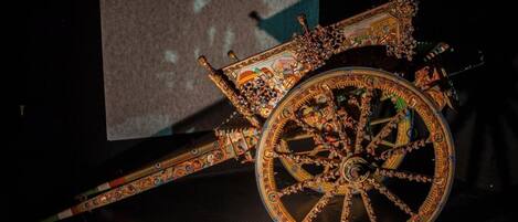 A large, ornate carriage with intricate designs and a large wheel.