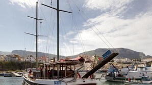 A sailing ship docked at a marina with a mountainous backdrop. - Kunesias (Cinisi)