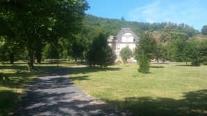 Un sendero que lleva a un edificio grande rodeado de árboles.
