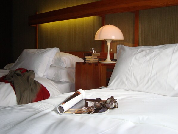 A hotel room with a bed, a nightstand with a lamp, and a magazine with glasses on it. - The Catalogne (Font-Romeu-Odeillo-Via)