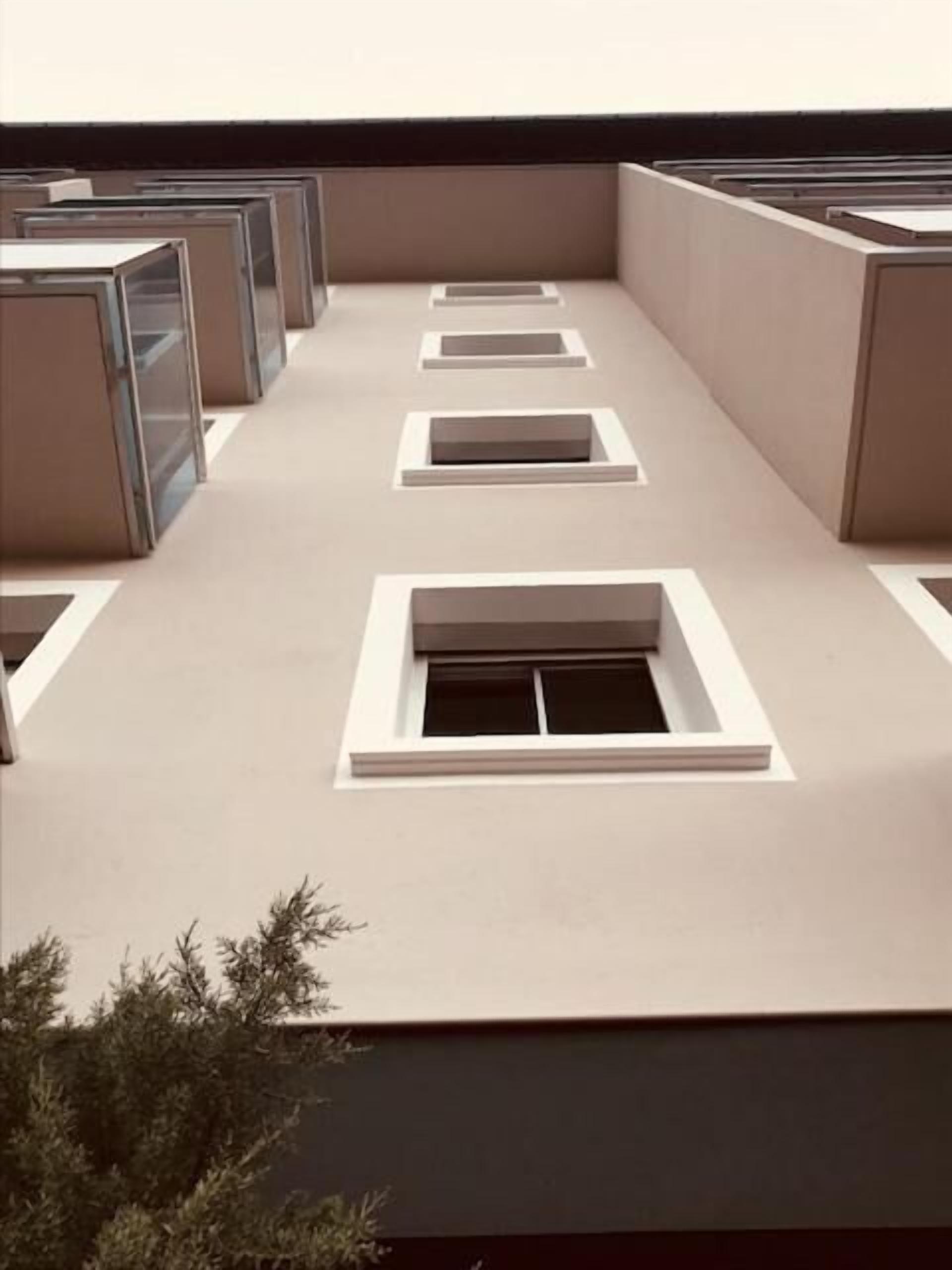 A modern building with multiple rectangular windows and a flat roof.