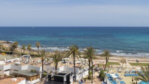 A beach resort with a pool area, lounge chairs, and palm trees. - Palia Sa Coma Playa (Sant Llorenc des Cardassar)